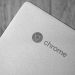 Detailed grayscale image focusing on a Chrome laptop logo, highlighting texture and design.