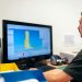 Engineer working on prosthetic design using specialized software in an office setting.