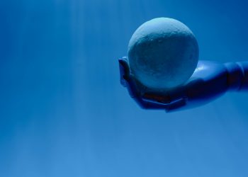 A robotic hand holds a glowing celestial sphere against a blue background, evoking a futuristic theme.