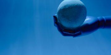 A robotic hand holds a glowing celestial sphere against a blue background, evoking a futuristic theme.