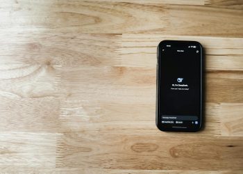 Mobile phone displaying AI chatbot interface on a wooden table