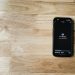 Mobile phone displaying AI chatbot interface on a wooden table