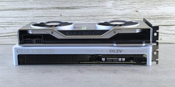 Two modern graphics cards stacked on a wooden surface, showcasing sleek design and advanced technology.