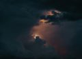 A captivating view of a dramatic stormy sky with glowing clouds breaking through darkness.