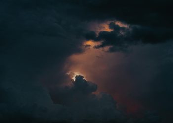 A captivating view of a dramatic stormy sky with glowing clouds breaking through darkness.