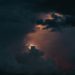 A captivating view of a dramatic stormy sky with glowing clouds breaking through darkness.