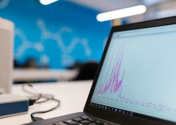Laptop displaying data analytics graph in a modern office setting, symbolizing growth and technology.