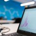 Laptop displaying data analytics graph in a modern office setting, symbolizing growth and technology.