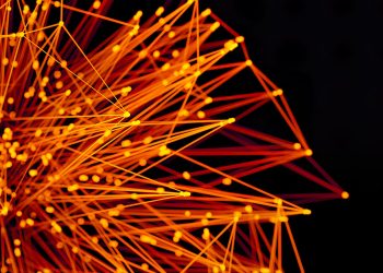 Vibrant orange lines and dots form an abstract network on a dark background, evoking technology and connectivity.