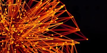 Vibrant orange lines and dots form an abstract network on a dark background, evoking technology and connectivity.