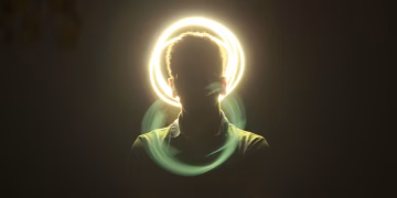 Artistic silhouette of a man with a vibrant halo light effect and motion blur on a dark background.