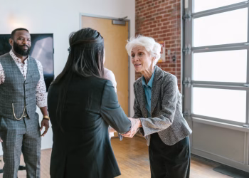 Three entrepreneurs meeting and shaking hands in a modern office setting.