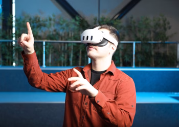 A man wearing a VR headset interacts with augmented reality indoors.