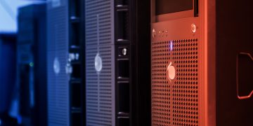 Close-up of tower servers in a data center with blue and red lighting.