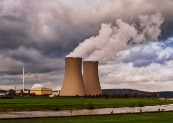 Scenic view of a nuclear power plant with cooling towers emitting steam in Hameln, Germany.
