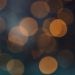 Abstract bokeh background with warm orange circles on a dark backdrop.