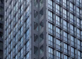 Close-up of a modern skyscraper's glass and steel facade in downtown Tokyo, Japan.