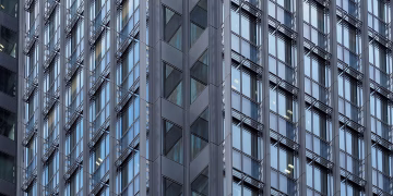 Close-up of a modern skyscraper's glass and steel facade in downtown Tokyo, Japan.