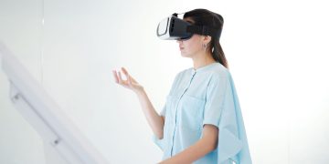 Young woman engaged in virtual reality experience with a headset indoors.