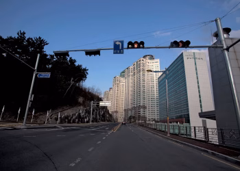 City street view featuring modern skyscrapers and a hotel under a clear blue sky.