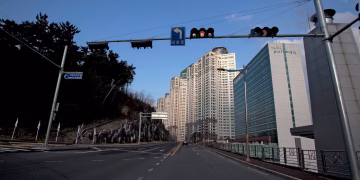 City street view featuring modern skyscrapers and a hotel under a clear blue sky.