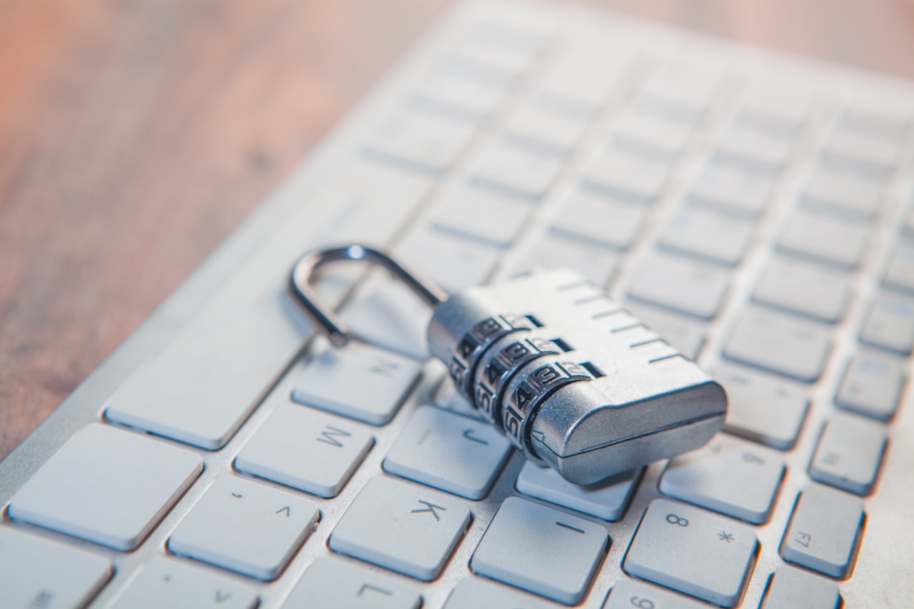 A combination lock rests on a computer keyboard.