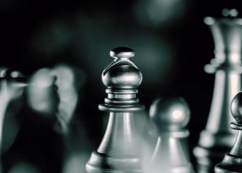 Artistic black and white close-up of chess pieces with selective focus, emphasizing strategic gameplay.