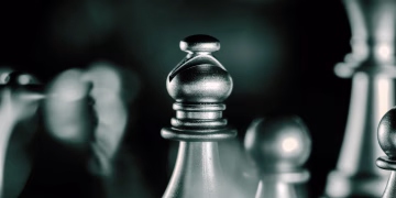 Artistic black and white close-up of chess pieces with selective focus, emphasizing strategic gameplay.