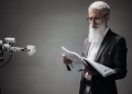 A robot arm assists a professional with a book and coffee in a modern office setup. Technology meets innovation.