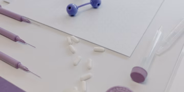 Medical tools and pills arranged on a table, showcasing a laboratory research setting.