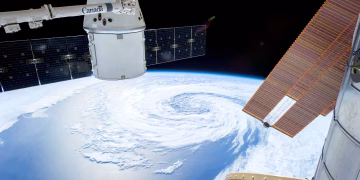 A mesmerizing view of Earth as seen from a space station with solar panels and satellite modules.