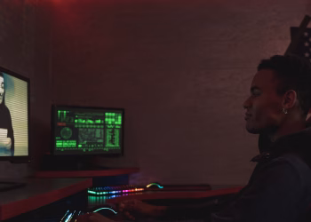 A cybersecurity professional monitors data systems in a dark room, emphasizing protection and vigilance.