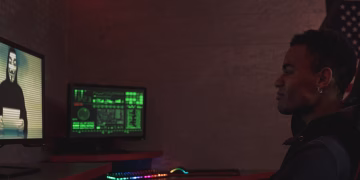 A cybersecurity professional monitors data systems in a dark room, emphasizing protection and vigilance.