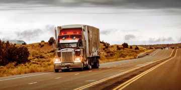 A large truck driving on a desert highway in Nevada, USA. Perfect for transportation themes.