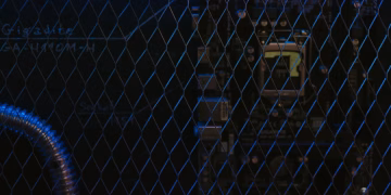Artistic view of a circuit board through metal mesh with blue lighting.