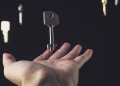 A mysterious scene of keys floating above an open hand against a dark background.