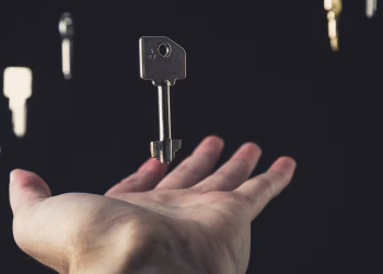 A mysterious scene of keys floating above an open hand against a dark background.