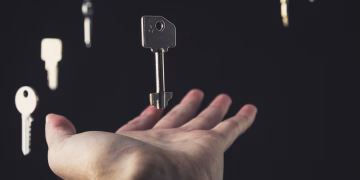 A mysterious scene of keys floating above an open hand against a dark background.