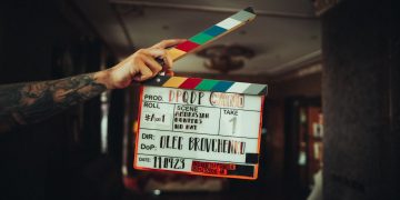 A person holding a clapper in their hand
