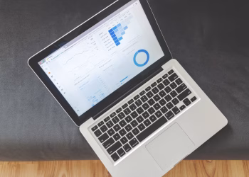 Overhead view of a laptop showing data visualizations and charts on its screen.