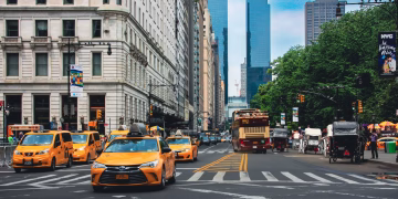 Yellow taxis and bustling traffic on a vibrant New York City street.