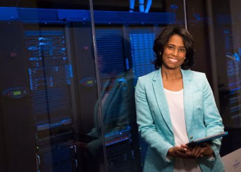 Smiling woman in data center showcasing technology expertise.