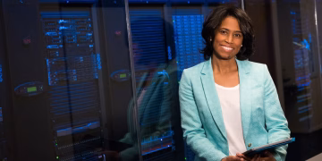 Smiling woman in data center showcasing technology expertise.