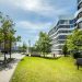 Contemporary business office building with curved architecture and trees in an urban setting.
