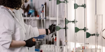 Scientists in lab coats work with test tubes in a modern laboratory.