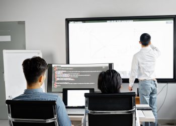 Team conducting a business presentation with technology in a modern office setting.