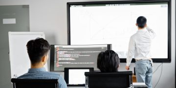 Team conducting a business presentation with technology in a modern office setting.