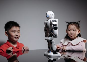 Kids amazed by a humanoid robot during an indoor play session, showcasing technology and learning.