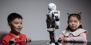 Kids amazed by a humanoid robot during an indoor play session, showcasing technology and learning.