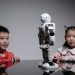 Kids amazed by a humanoid robot during an indoor play session, showcasing technology and learning.
